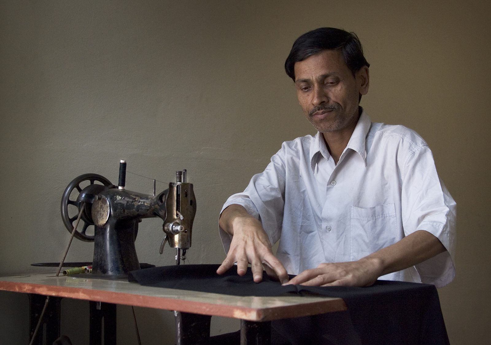 A woman in rural India learning tailoring at a sewing machine during a training session